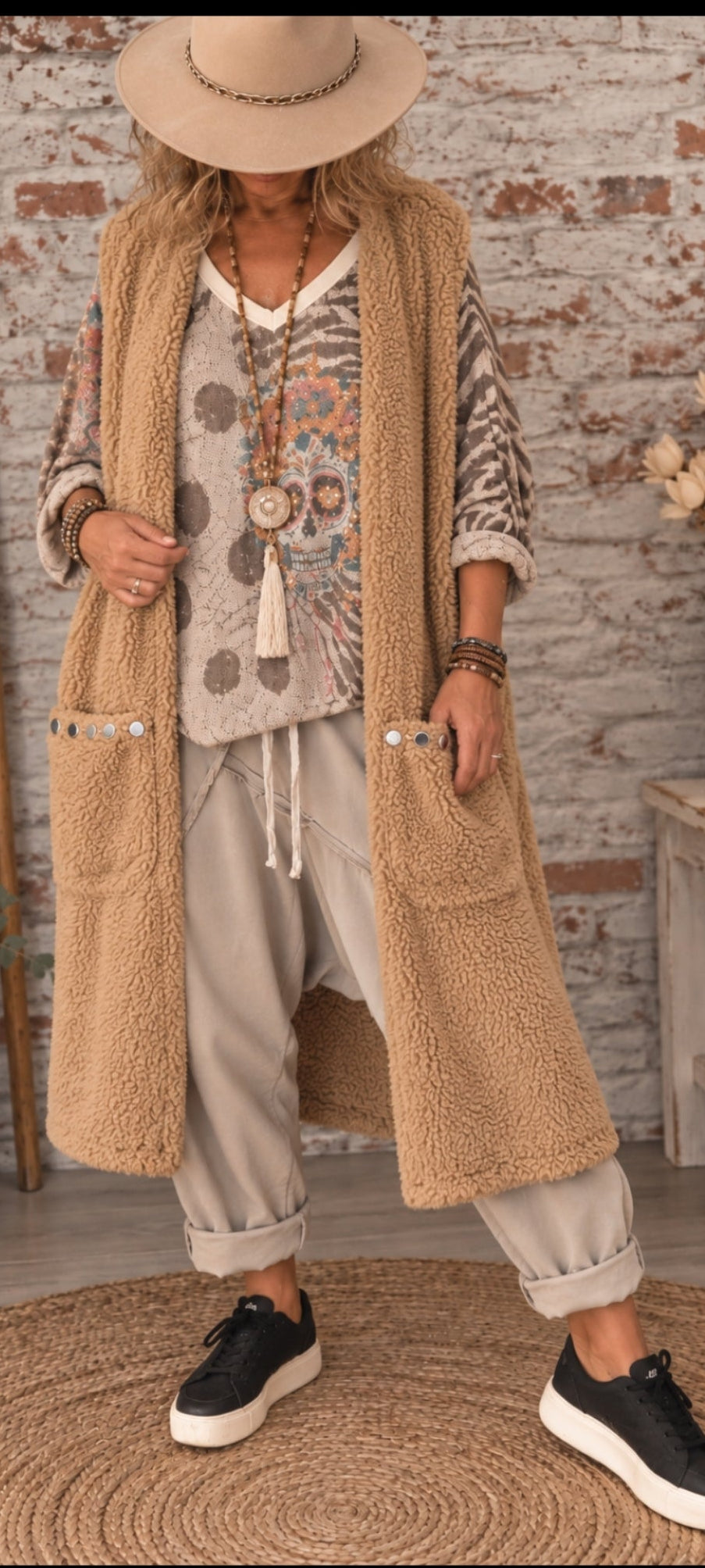 veste longue sans manches style moumoute, très bohème et décontractée.